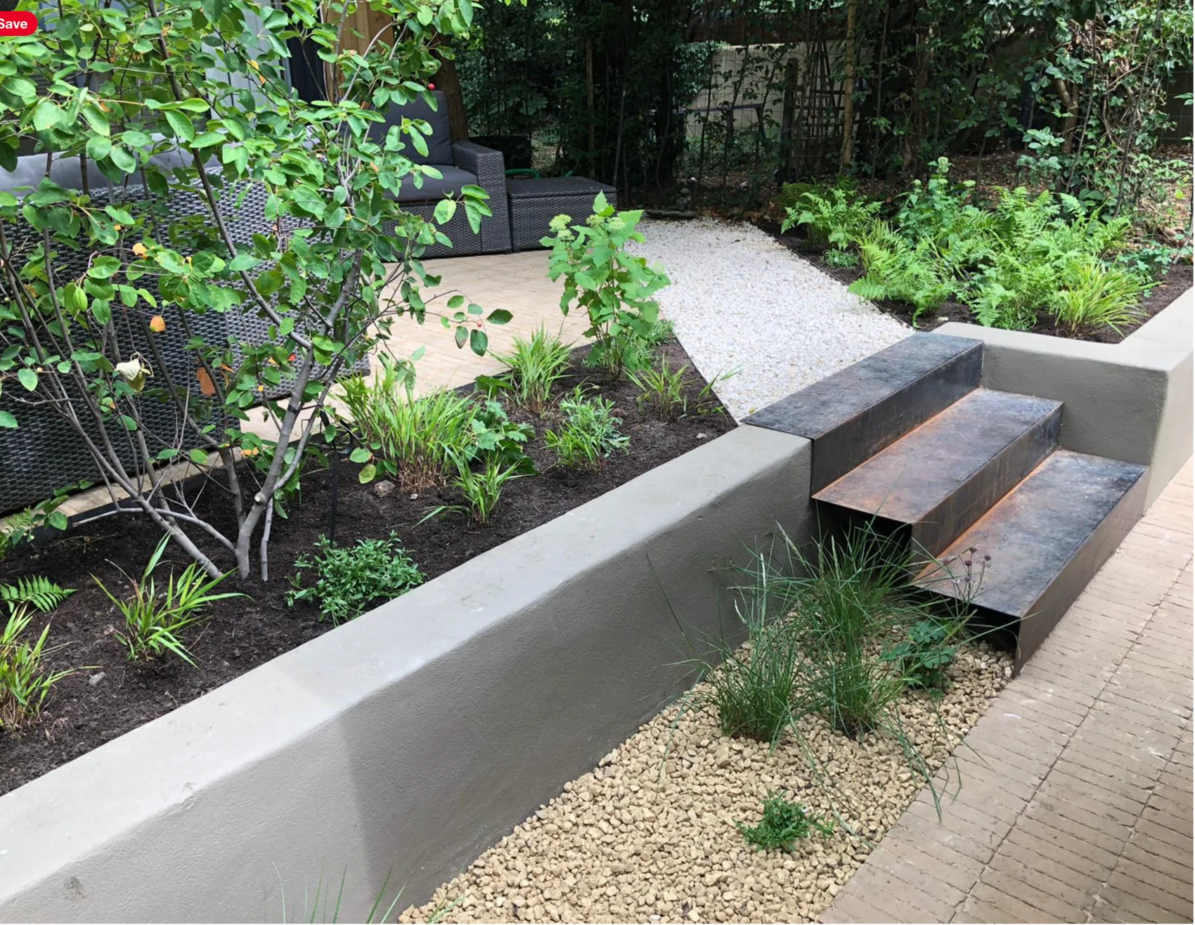 Shady Brixton Victorian garden with white rendered walls and corten steps